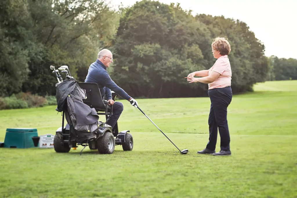 Disabled man in wheelchair playing golf with friend